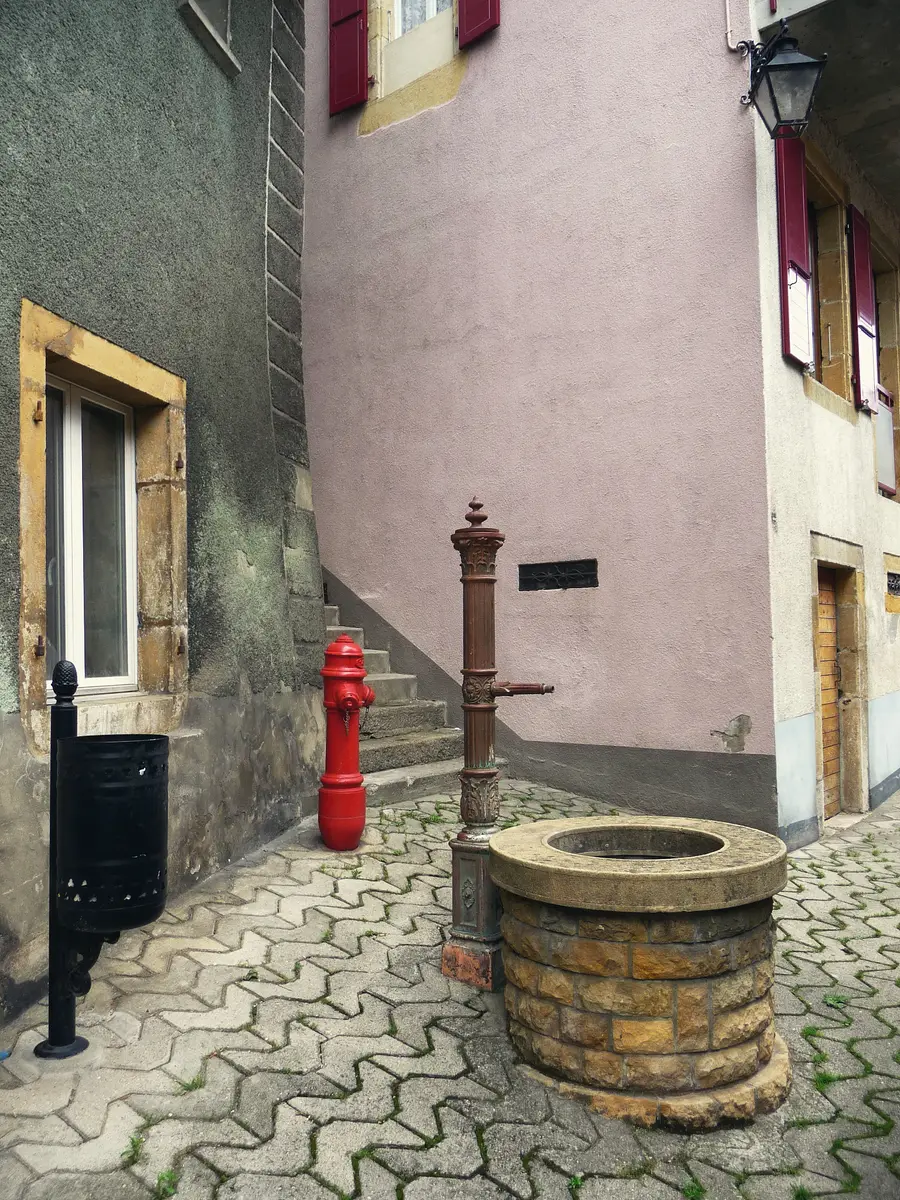 An old-town corner in Grandson, with its stone fountain